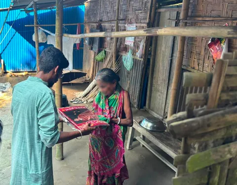 Volunteer showing clothes to an elderly woman during Durga Puja